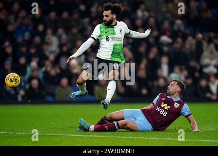 Mohamed Salah del Liverpool (a sinistra) viene affrontato dal Burnley Charlie Taylor durante la partita di Premier League a Turf Moor, Burnley. Data immagine: Martedì 26 dicembre 2023. Foto Stock