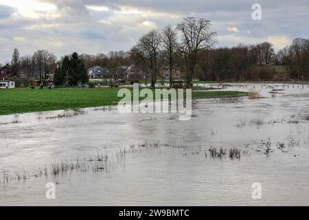 Olfen, NRW, Germania. 26 dicembre 2023. I seminterrati e i giardini nella vicina Olfen stanno iniziando a inondare. Il fiume Stever e le sue sponde hanno gravemente allagato gran parte della campagna circostante. Vicino al ponte Stever, uno storico ponte a tre archi che trasportava piccole imbarcazioni in un canale sul fiume Stever (ora è un ponte pedonale), i campi circostanti sono allagati al ginocchio. Gran parte della Germania settentrionale e occidentale hanno visto inondazioni dopo settimane di forti piogge. La previsione è per più pioggia. Crediti: Imageplotter/Alamy Live News Foto Stock