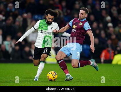 Mohamed Salah del Liverpool (a sinistra) viene affrontato dal Burnley Charlie Taylor durante la partita di Premier League a Turf Moor, Burnley. Data immagine: Martedì 26 dicembre 2023. Foto Stock