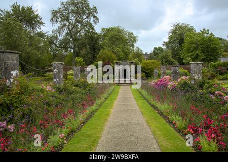 arcata in pietra su sentiero con giardino all'inglese Foto Stock