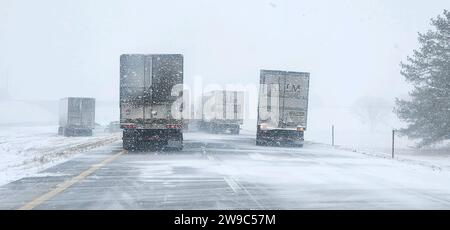 Lincoln, Nebraska, USA. 26 dicembre 2023. I camion viaggiano lungo l'Interstate 80 in Nebraska lunedì in condizioni simili a Blizzard. I soldati della Nebraska State Patrol hanno risposto a quasi 150 incidenti di veicoli e camion legati alle condizioni meteorologiche sulle strade del Nebraska il giorno di Natale. Sulla i-80 sono stati spostati diversi camion, alcuni dei quali sono scivolati fuori strada a causa di una tormenta causata da strade ghiacciate e scarsa visibilità. Una pericolosa tormenta invernale ha portato la neve e le condizioni di sabbia bianca su strade e porzioni degli Stati Uniti centrali per i milioni di viaggiatori durante le vacanze. (Immagine di credito: © Nebraska State Foto Stock