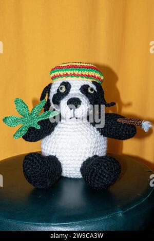 Gehäkelter Reggae Panda Bär mit Jamaika Mütze, Hanf Blatt und Rasterlöckchen Foto Stock