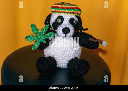 Gehäkelter Reggae Panda Bär mit Jamaika Mütze, Hanf Blatt und Rasterlöckchen Foto Stock