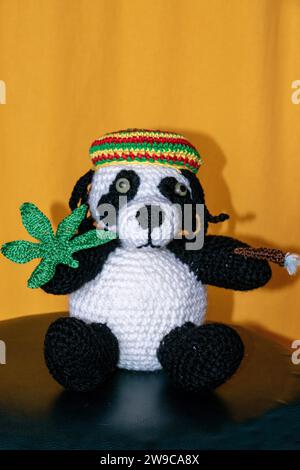 Gehäkelter Reggae Panda Bär mit Jamaika Mütze, Hanf Blatt und Rasterlöckchen Foto Stock