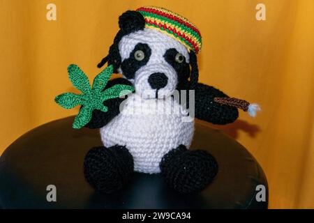 Gehäkelter Reggae Panda Bär mit Jamaika Mütze, Hanf Blatt und Rasterlöckchen Foto Stock