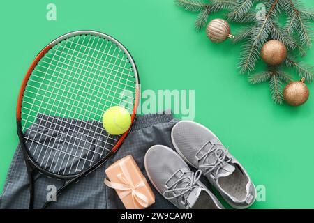 Cornice realizzata con attrezzatura da tennis con decorazioni natalizie e regalo su sfondo verde Foto Stock