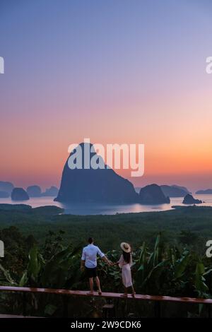Un paio di uomini e donne che guardano l'alba al punto panoramico di Sametnangshe nella Baia di Phangnga con la foresta di mangrovie e le scogliere calcaree nel Mare delle Andamane, Sametnangshe Phangnga Thailandia Foto Stock