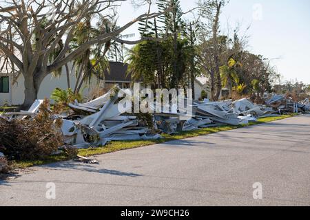 Mucchi di rifiuti sul lato della strada da case gravemente danneggiate dopo l'uragano nella zona residenziale delle case mobili della Florida. Conseguenze del disastro naturale Foto Stock