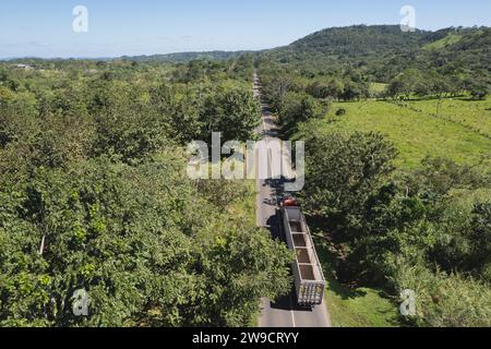 Il camion da carico vuoto si sposta su asfalto in un contesto agricolo Foto Stock