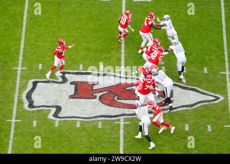 Una visione generale del quarterback dei Kansas City Chiefs Patrick Mahomes (15) prende lo scatto alla linea di scrimmage sul logo dei Chiefs a centrocampo contro i Las Vegas Raiders durante una partita di football NFL, lunedì 25 dicembre 2023, a Kansas City, Mo. I Raiders sconfissero i Chiefs 20-14. Foto Stock