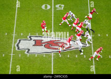 Una visione generale del quarterback dei Kansas City Chiefs Patrick Mahomes (15) prende lo scatto alla linea di scrimmage sul logo dei Chiefs a centrocampo contro i Las Vegas Raiders durante una partita di football NFL, lunedì 25 dicembre 2023, a Kansas City, Mo. I Raiders sconfissero i Chiefs 20-14. Foto Stock