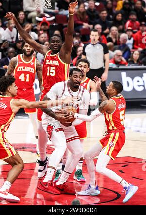 Chicago, Stati Uniti. 26 dicembre 2023. Andre Drummond (C) dei Chicago Bulls ottiene un rimbalzo durante la partita della stagione regolare NBA tra gli Atlanta Hawks e i Chicago Bulls a Chicago, negli Stati Uniti, il 26 dicembre 2023. Crediti: Joel Lerner/Xinhua/Alamy Live News Foto Stock