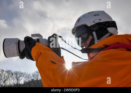 Jilin, la provincia cinese di Jilin. 7 dicembre 2023. Zhang Jian, capo del team fotografico del Songhua Lake Resort, scatta foto nel suo posto di lavoro a Jilin City, nella provincia di Jilin, nella Cina nord-orientale, 7 dicembre 2023. Per ANDARE CON "Across China: Shutterbug in nordest China record crescente popolarità sport invernali" credito: Zhang Nan/Xinhua/Alamy Live News Foto Stock