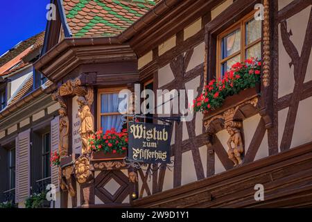 Ribeauville, Francia - 2 giugno 2023: Pfifferhus, ristorante alsaziano di winstub in una casa a graticcio con fiori in un villaggio sulla strada del vino alsaziano Foto Stock