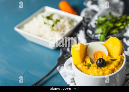 Piatto tradizionale chiamato aji de gallina con una porzione di riso, molto popolare nella gastronomia peruviana. Foto Stock