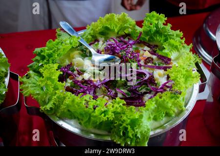 Insalata con aranci, pomodori e mela su un piatto a buffet. Foto Stock