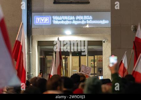 Il 26 dicembre 2023, la gente sventola le bandiere della Polonia al di fuori dello studio televisivo statale TVP di Varsavia, Polonia. Le persone si sono riunite al di fuori dello studio statale TVP nella protesta in corso contro la mossa della coalizione pro-europea appena eletta per reimporre l'integrità e l'obiettività nei media pubblici. Varsavia Polonia dimostrazione in difesa di TVP. 2023/12/26 Copyright: XMarekxAntonixIwanczukx MAI08473 Foto Stock