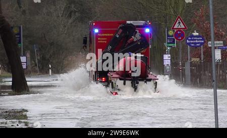 Hannover, Germania. 27 dicembre 2023. Il servizio di soccorso idrico del dipartimento dei vigili del fuoco di Hannover guida una barca attraverso una strada allagata tra Hannover e Hemmingen (immagine fissa dal video dpa). Un uomo di 75 anni era in bicicletta lungo la strada chiusa a mezzogiorno ed è caduto in acque profonde ed è stato spazzato via. Era in grado di aggrapparsi a un albero. I vigili del fuoco sono stati in grado di localizzare e salvare l'uomo usando dei droni. Credito: Julian Stratenschulte/dpa/Alamy Live News Foto Stock