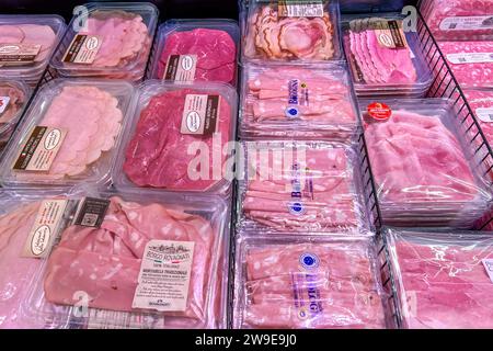 Italia - 24 dicembre 2023: Salumi a fette confezionati in vassoi di plastica trasparente confezionati sottovuoto di vari tipi e marchi esposti in conta refrigerata Foto Stock