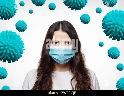 Concetto di diffusione dell'infezione da COVID-19 da coronavirus. Ritratto di una ragazza con una maschera protettiva circondata da batteri del coronavirus su sfondo bianco. Foto Stock