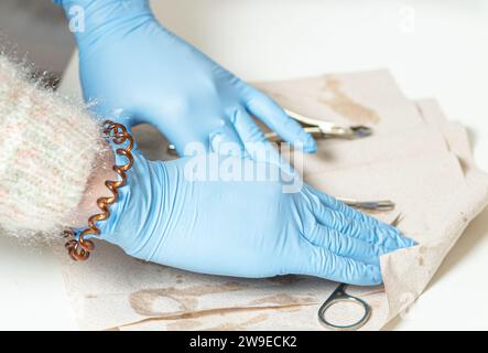 Manicurista in guanti blu disinfetta gli strumenti per manicure. Foto Stock