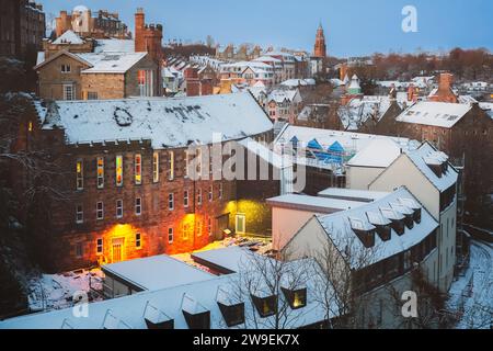 Pittoresco e storico Dean Village coperto di neve lungo il Water of Leith durante un crepuscolo invernale a Edimburgo, Scozia, Regno Unito. Foto Stock