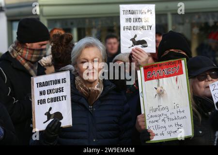 Bungay, Regno Unito. 26 dicembre 2023. Cacciare i manifestanti tenere cartelli raffiguranti la caccia come crudele durante la manifestazione. Azione contro la crudeltà degli animali, protesta si tenne nel centro della città, Bungay mentre i Waveney e Norfolk Harriers sfilano per le strade a sostegno dei contadini. I manifestanti hanno affermato che, nonostante il divieto di caccia tradizionale alla volpe, gli animali vengono ancora uccisi durante l'alternativa alla caccia sulle tracce e chiedono un divieto totale. (Foto di Martin Pope/SOPA Images/Sipa USA) credito: SIPA USA/Alamy Live News Foto Stock