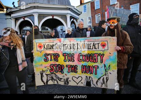 Bungay, Suffolk, Regno Unito. 26 dicembre 2023. I manifestanti, alcuni indossano maschere facciali di animali si trovano dietro uno striscione che dice: "Uccidere per piacere è Un vile atto - fermare la crudeltà, fermare la caccia durante la manifestazione. Azione contro la crudeltà degli animali, protesta si tenne nel centro della città, Bungay mentre i Waveney e Norfolk Harriers sfilano per le strade a sostegno dei contadini. I manifestanti hanno affermato che, nonostante il divieto di caccia tradizionale alla volpe, gli animali vengono ancora uccisi durante l'alternativa alla caccia sulle tracce e chiedono un divieto totale. (Immagine di credito: © Martin Pop Foto Stock