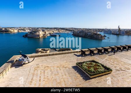 Vista dagli Upper Barrakka Gardens sulla Saluting Battery e sul Grand Harbour di Valletta, Malta, verso le Tre Città di Birgu, Senglea e Cospicua. L'Ordine di San Giovanni costruì la batteria negli anni 1560; spara ancora saluti giornalmente tranne la domenica a mezzogiorno e alle 16:00, una tradizione mantenuta fin dall'epoca del dominio coloniale britannico. Foto Stock
