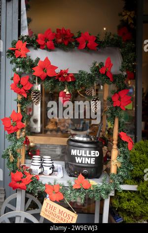 Tavola per la vendita di VIN brulé, decorazione a forma di ghirlanda poinsettia, tazze per VIN brulé. Atmosfera natalizia nella caffetteria. Termocamera. Foto Stock