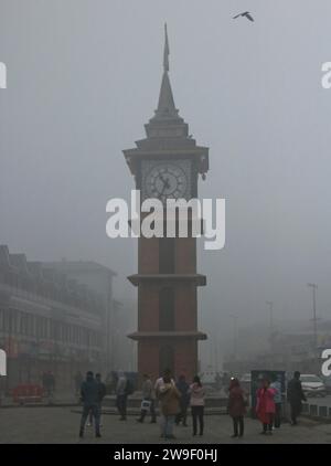 Srinagar, India. 27 dicembre 2023. 27 dicembre 2023, Srinagar Kashmir, India: La gente cammina vicino alla torre dell'orologio (Ghanta Ghar) in mezzo alla nebbia pesante a Srinagar. Nella valle del Kashmir continuano a prevalere forti ondate di freddo e nebbia. Il 27 dicembre 2023, Srinagar Kashmir, India. (Foto di Firdous Nazir/Eyepix Group) credito: Eyepix Group/Alamy Live News Foto Stock