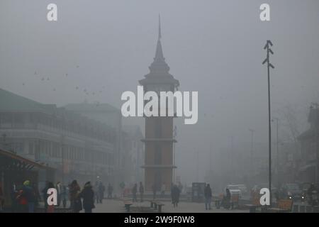 Srinagar Kashmir, India. 27 dicembre 2023. La gente cammina vicino alla torre dell'orologio (Ghanta Ghar) in mezzo alla nebbia pesante di Srinagar. Nella valle del Kashmir continuano a prevalere forti ondate di freddo e nebbia. Il 27 dicembre 2023, Srinagar Kashmir, India. (Immagine di credito: © Firdous Nazir/eyepix via ZUMA Press Wire) SOLO USO EDITORIALE! Non per USO commerciale! Foto Stock