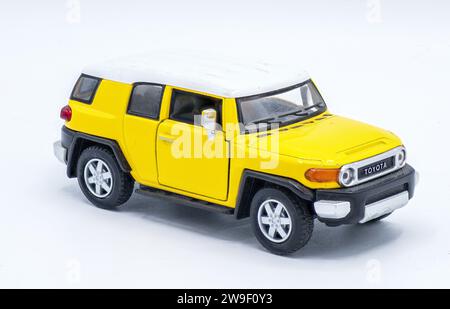 10 ottobre 2023 auto pressofuse Toyota FJ Cruiser modello giocattolo da collezione isolato su sfondo bianco, fuoco solare giallo o colore fuoco solare, vista frontale destra Foto Stock