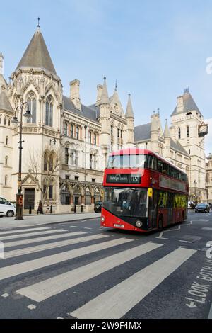 London, UK - March 16 2023; Red double decker bus passing Royal Courts of Justice building Foto Stock