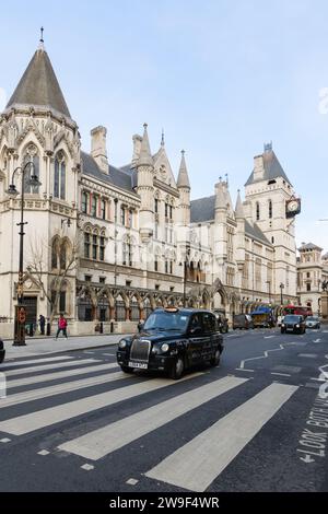 Londra, Regno Unito - 16 marzo 2023; taxi nero di Londra che passa accanto all'edificio Royal Courts of Justice Foto Stock