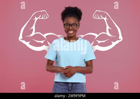 Donna felice e illustrazione di braccia muscolari dietro di lei su sfondo rosa Foto Stock