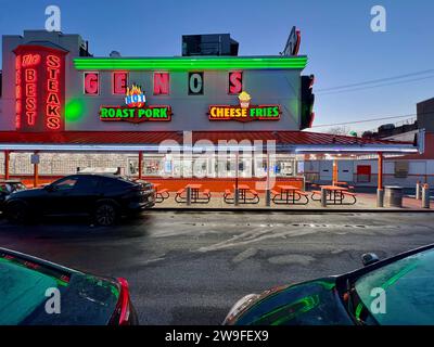 Geno's Steaks, un pilastro del mercato italiano di Filadelfia, si illumina al neon all'alba. Foto Stock