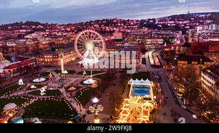 Punto di vista dei droni sul mercatino di Natale di Stoccarda - sul Mitte di Stoccarda (Schlossplatz Stoccarda). Dietro la ruota panoramica. E castello , movimento sfocato p Foto Stock