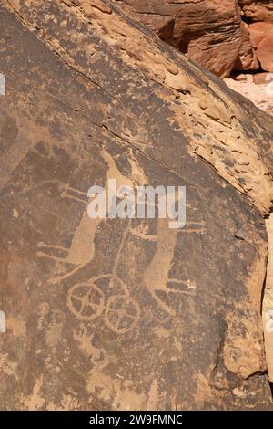 Disegno in roccia di un veicolo a ruote trainato da due animali a Jubbah, nella provincia di Hail, nel deserto Arabico Foto Stock