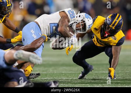 Charlotte, North Carolina, USA. 27 dicembre 2023. Il running back dei North Carolina Tar Heels OMARION HAMPTON (28) viene placcato durante la prima metà della partita del Mayo Bowl 2023 tra i North Carolina Tar Heels e i West Virginia Mountaineers al Bank of America Stadium di Charlotte, NC, il 27 dicembre 2023. (Immagine di credito: © Cory Knowlton/ZUMA Press Wire) SOLO USO EDITORIALE! Non per USO commerciale! Foto Stock