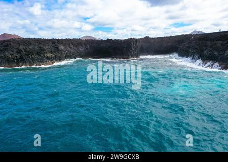 Vista panoramica aerea di Los Hervideros. Costa sudoccidentale, aspra costa vulcanica, surf forte, grotte marine, colline di lava rossa. Lanzarote, Isole Canarie, Spa Foto Stock