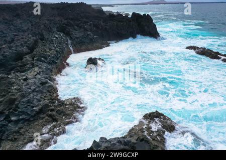 Vista panoramica aerea di Los Hervideros. Costa sudoccidentale, aspra costa vulcanica, surf forte, grotte marine, colline di lava rossa. Lanzarote, Isole Canarie, Spa Foto Stock