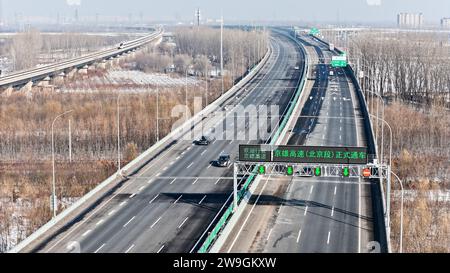 (231228) -- PECHINO, 28 dicembre 2023 (Xinhua) -- questa foto aerea scattata il 28 dicembre 2023 mostra veicoli a motore che corrono in una sezione della superstrada Pechino-Xiong'an a Pechino, capitale della Cina. Un nuovo segmento della superstrada Pechino-Xiong'an aperto al traffico giovedì, segnando il completamento dell'intera superstrada, secondo l'autorità cinese per i trasporti. La superstrada diretta tra Pechino e la nuova area di Xiong'an, nella provincia di Hebei nella Cina settentrionale, il Ministero dei trasporti ha dichiarato che il tempo di guida tra la quinta circonvallazione sud-occidentale di Pechino e la nuova area di Xiong'an sarà ridotto a un'ora. Foto Stock