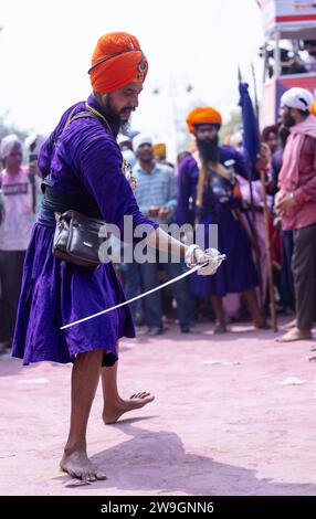 Maschio Sikh (Nihang Sardar) che esegue arte marziale come cultura durante la celebrazione di Hola Mohalla all'Anandpur Sahib on holi festival. Foto Stock