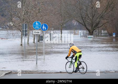 Pirna, Germania. 28 dicembre 2023. Un ciclista si trova su una strada prima delle inondazioni dell'Elba. La situazione delle inondazioni in Sassonia rimane tesa, soprattutto lungo l'Elba. Credito: Sebastian Kahnert/dpa/Alamy Live News Foto Stock