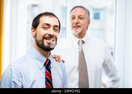 Senior manager che mette la mano sul sonoro di un collega Foto Stock