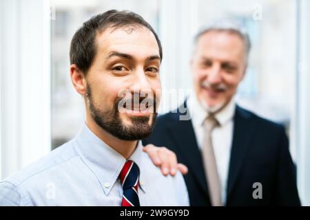 Senior manager che mette la mano sul sonoro di un collega Foto Stock