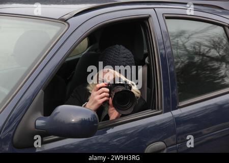 Junge Frau fotografiert heimlich aus dem Auto heraus und beobachtet ihre Zielperson Junge Frau fotografiert heimlich aus dem Auto heraus und beobachtet ihre Zielperson *** la giovane donna prende segretamente foto dalla sua auto e osserva il suo obiettivo la giovane donna prende segretamente foto dalla sua auto e osserva il suo obiettivo Foto Stock