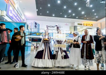Donne kazake vestite con un costume tradizionale durante la cerimonia di incontro e saluto uno sposo in un aeroporto di Aqtobe Kazakistan Foto Stock