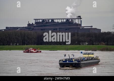 Frachtschiff auf dem Rhein bei Duisburg-Beeckerwerth, Industriekulisse des ThyssenKrupp Steel Stahlwerk a Bruckhausen, Hochwasser, NRW, Deutschland, Binnenschifffahrt *** nave da carico sul Reno vicino Duisburg Beeckerwerth, sfondo industriale delle acciaierie ThyssenKrupp in Bruckhausen, navigazione interna, Germania Foto Stock